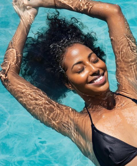 Happy woman relaxing in a swimming pool