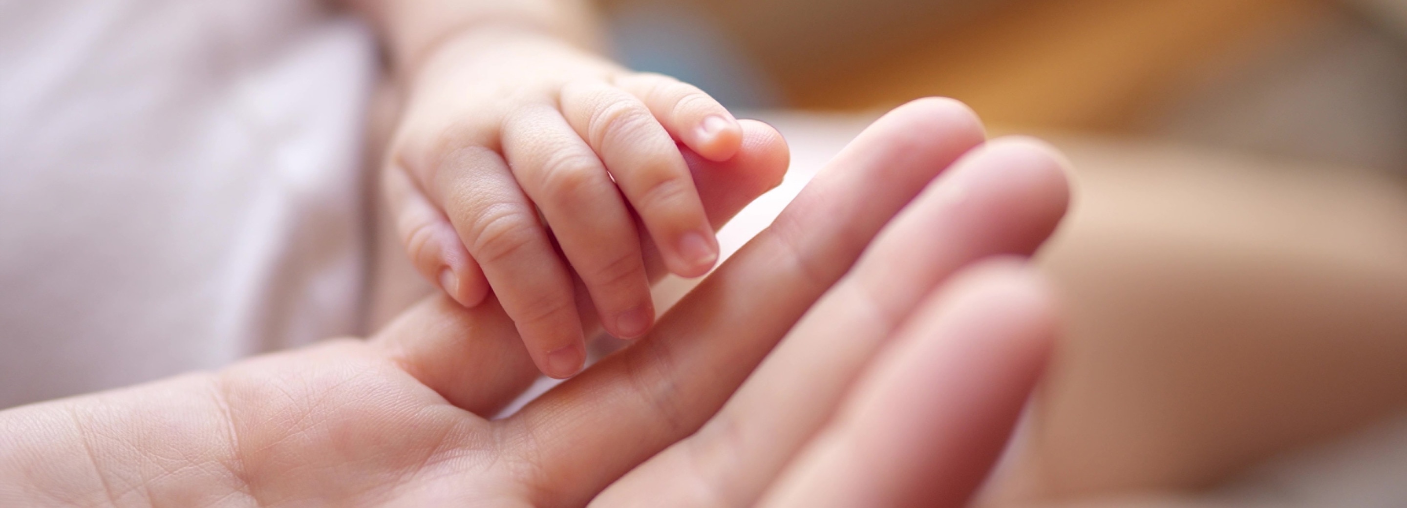 tangan bayi sedang memegang jari orang tua nya