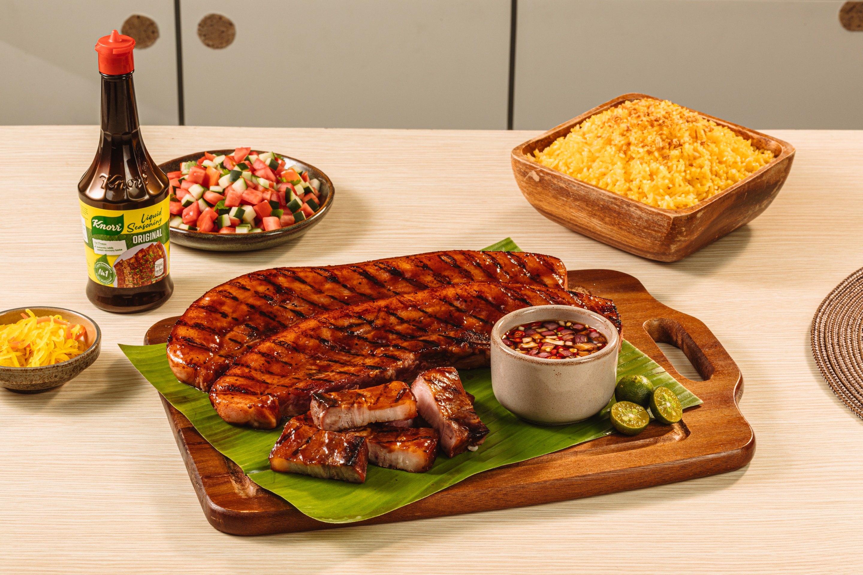 Slabs of grilled liempo served with dipping sauce and rice.