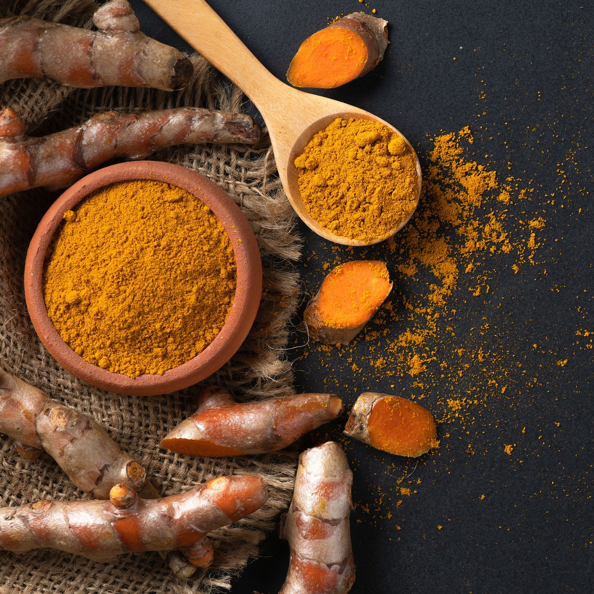 Turmeric Powder in Wooden Spoon