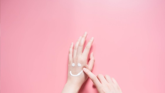 Woman applying hand lotion that has not expired to her hands