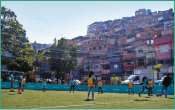 Mulheres jogando futebol em um campo da comunidade