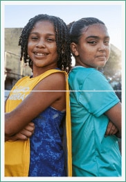 Duas garotas de costas, com os braços cruzados e sorrindo