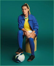 Tamires Cássia, sentada e com uma bola no pé
