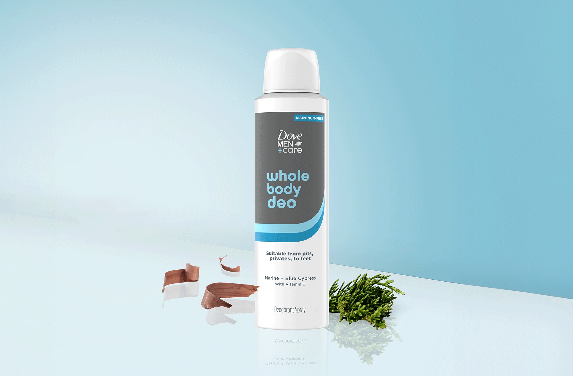 Marine and Blue Cypress Whole Body Deo Spray sobre un fondo azul claro. En cada lado del paquete, se pueden ver las virutas de madera de cedro y ciprés azul.