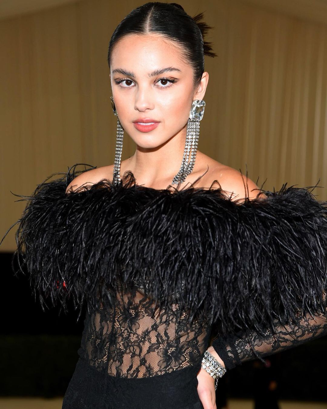 Rosie Huntington Whiteley wearing golden earrings and a low ponytail. 