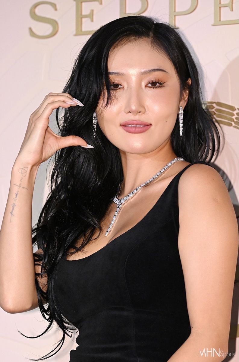 A close-up of Hwasa with long hair and black dress.