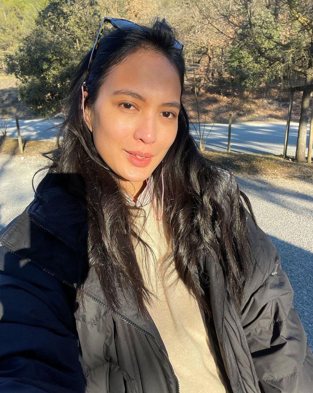 Asian woman with long hair wearing an oversized black jacket 