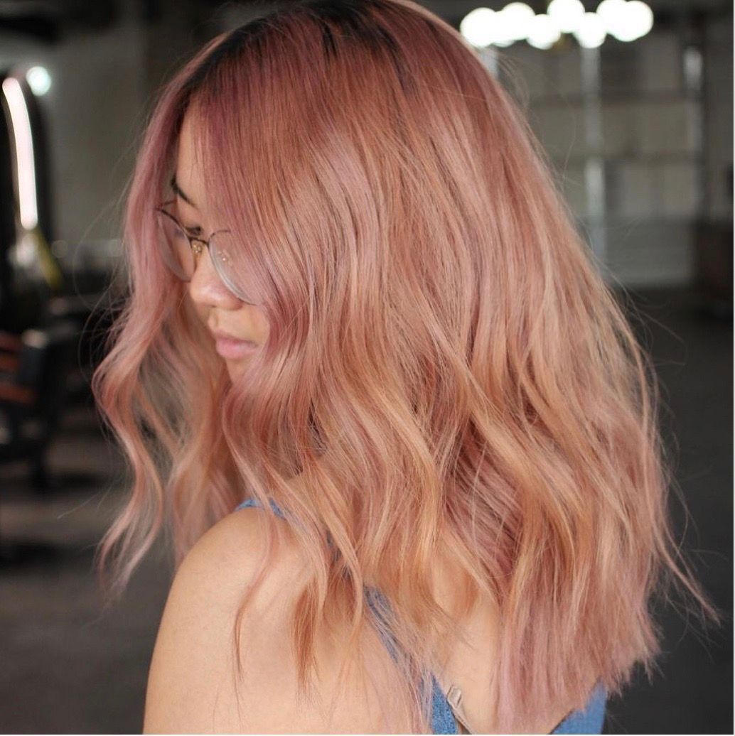 Asian girl with glasses and pinkish brown wavy hair.