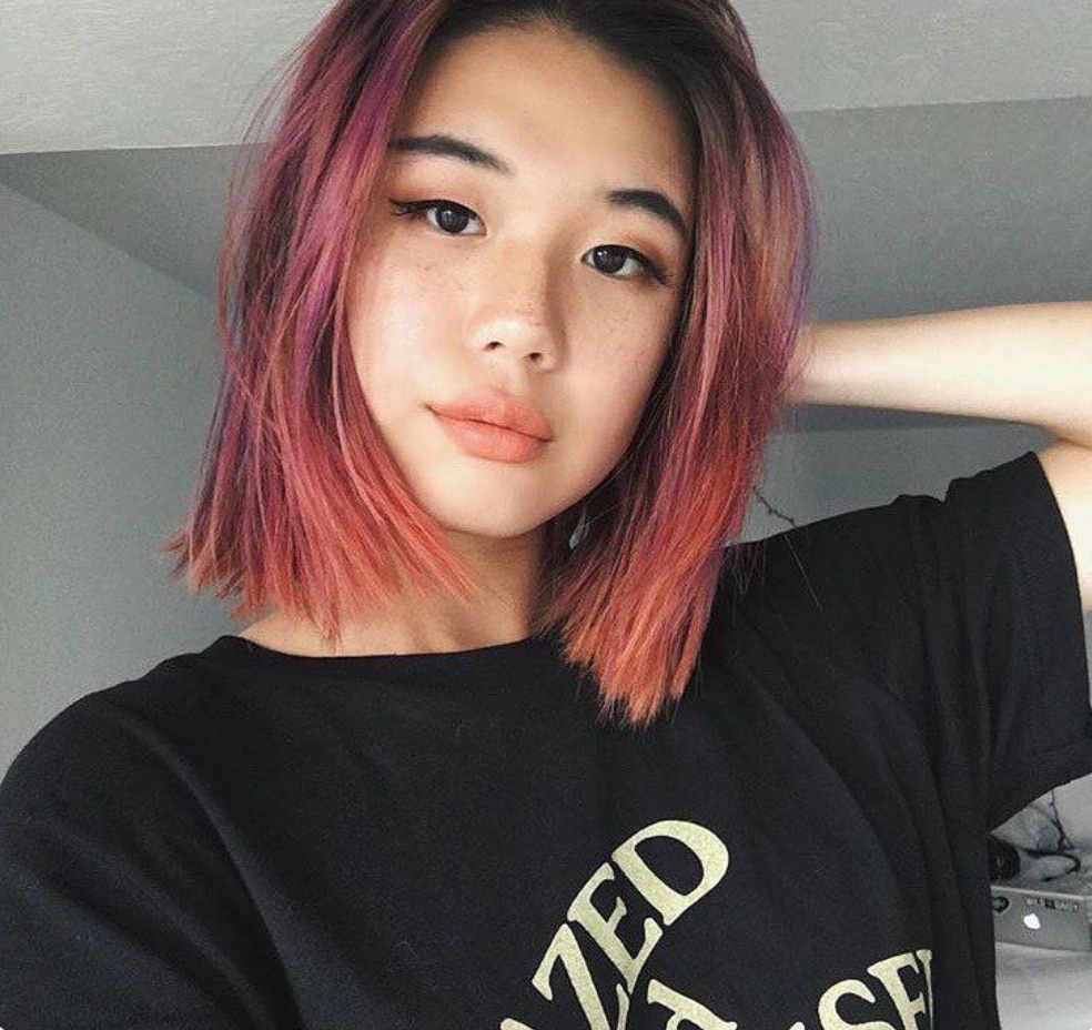 Portrait of an Asian girl with pink hair and orange highlights
