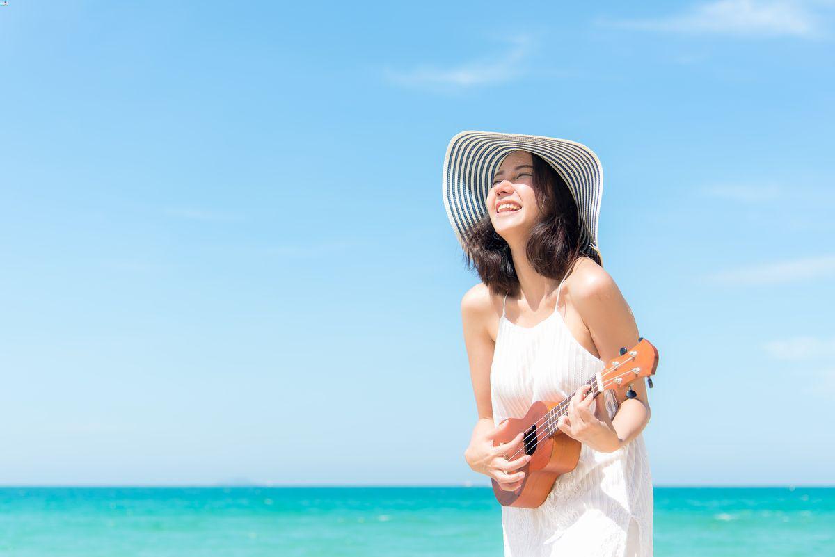 Woman on the beach with ukulele 