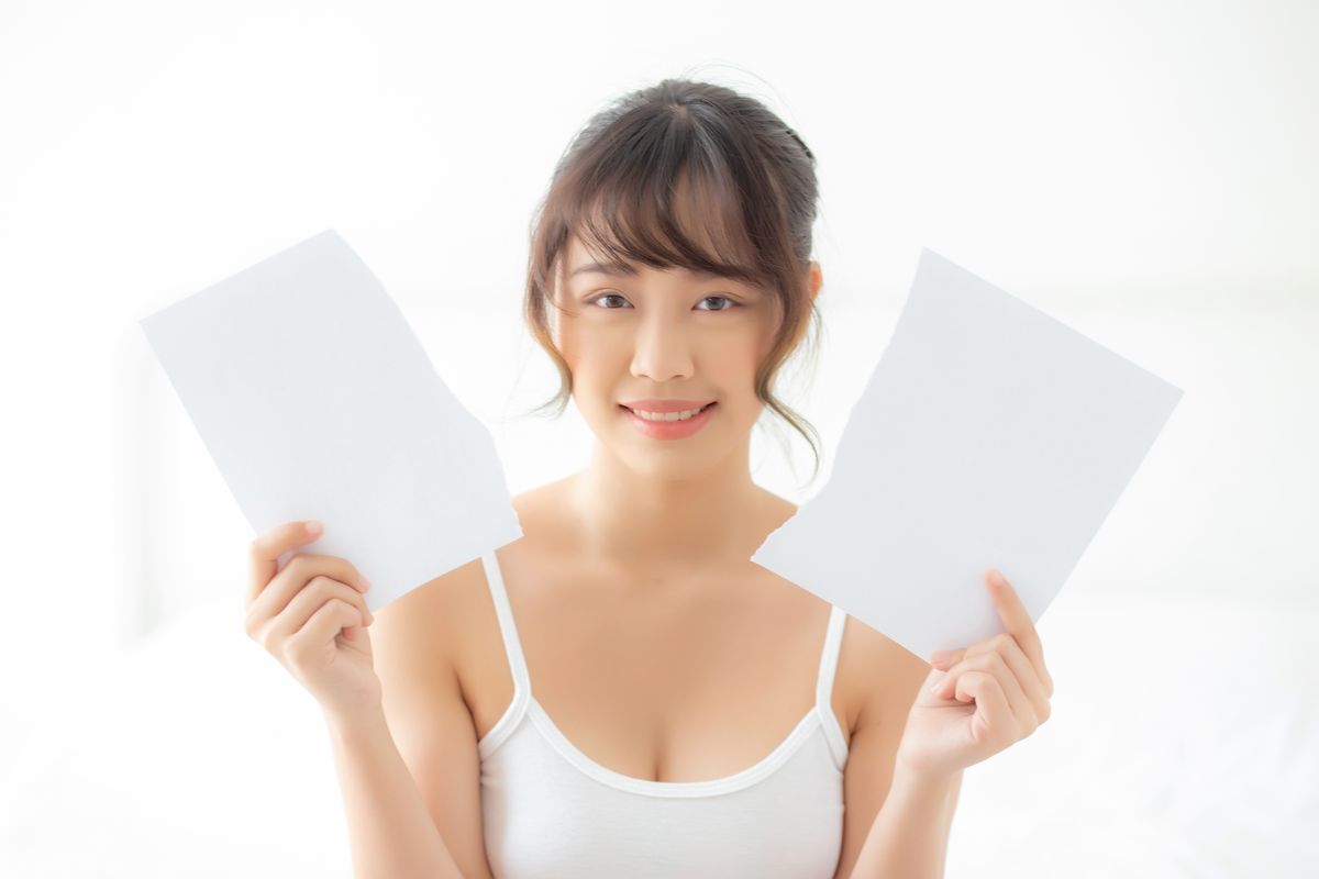 Girl holds two pieces of torn paper