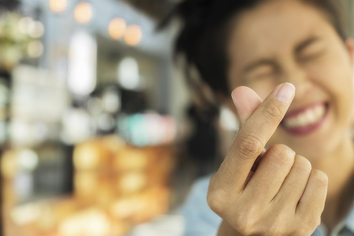 miling Asian woman finger heart