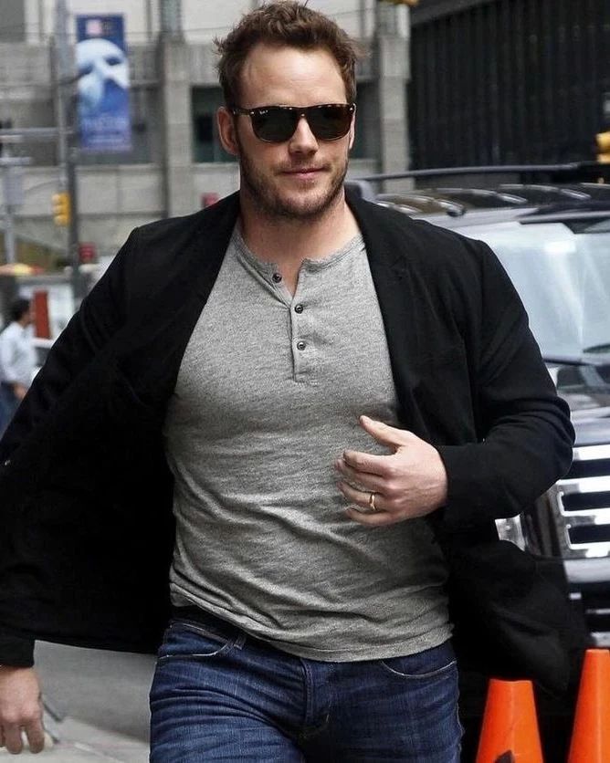 A portrait of Chris Pratt wearing gray Henley and black blazer.