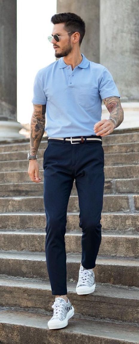 A portrait of man wearing light blue polo and navy chino pants.