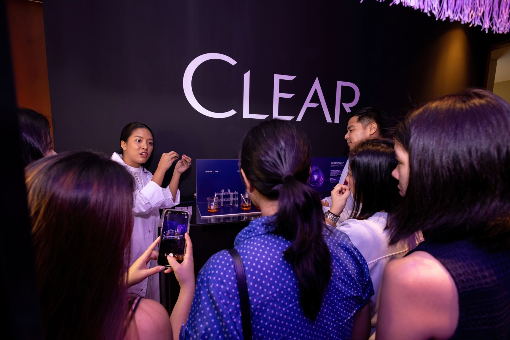 People gathered around a woman doing a presentation.