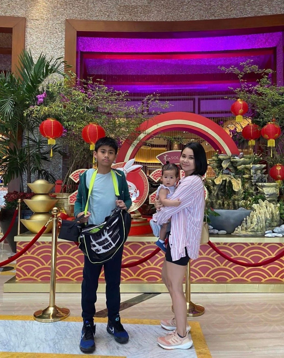 Asian family with mom, young boy, and baby girl with Chinese lanterns in the background.