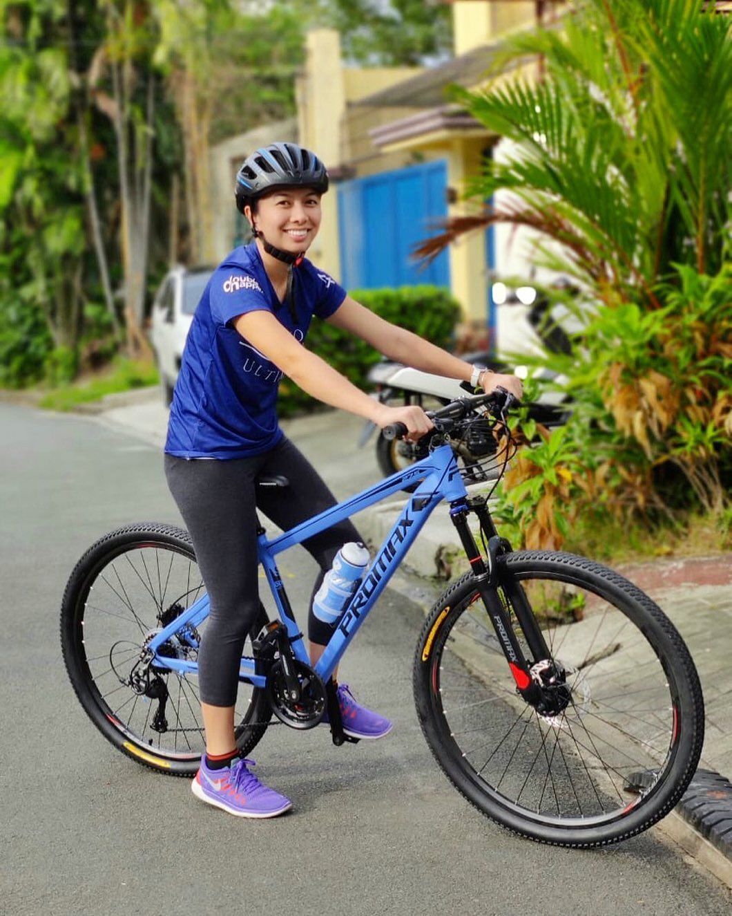 A woman riding on a blue bicycle.