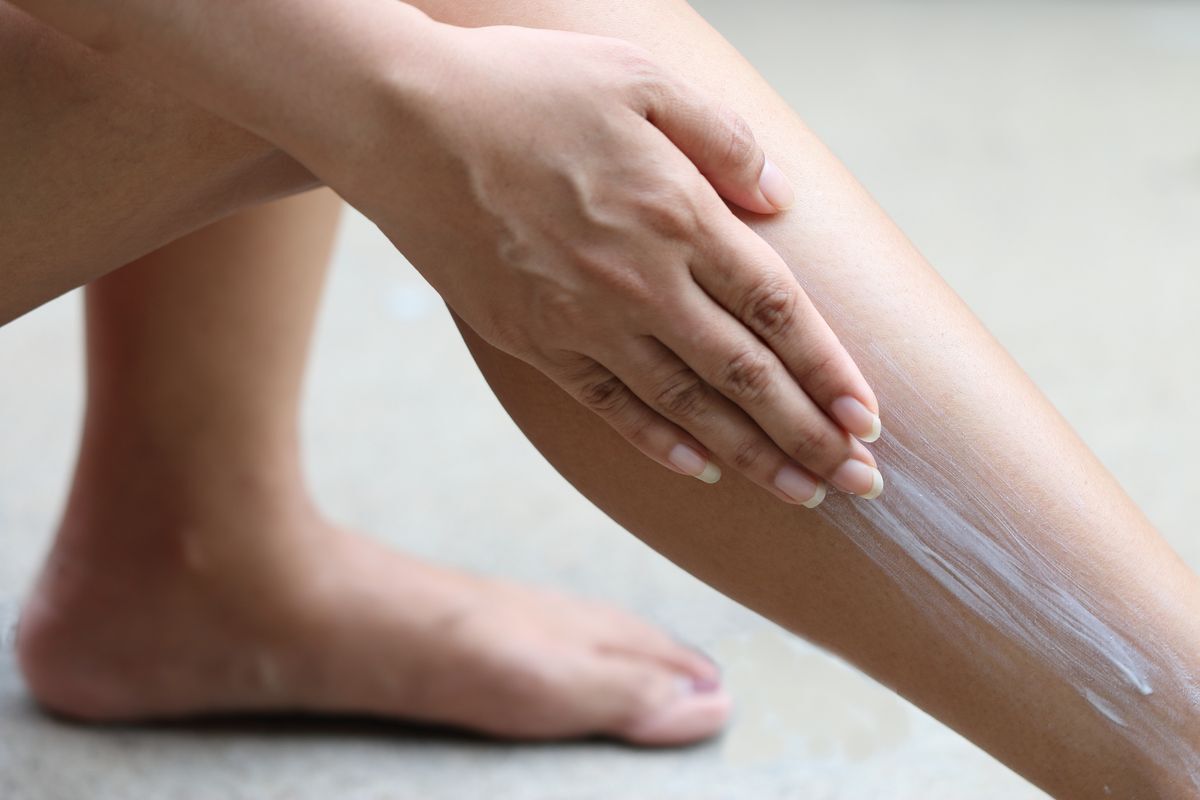 Woman applying lotion on her legs.