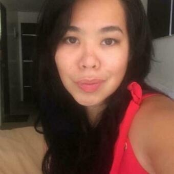 Smiling woman with long, black hair wearing a red top