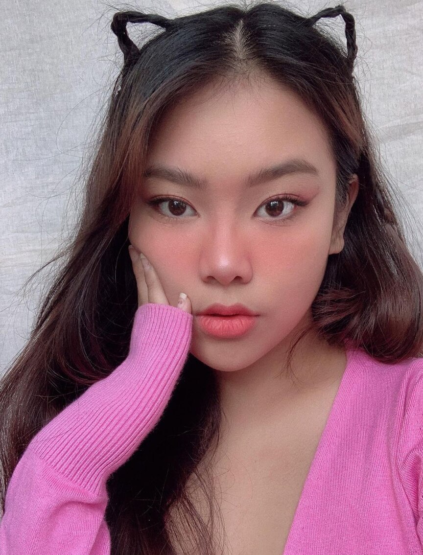 A woman with long brown hair and small braids