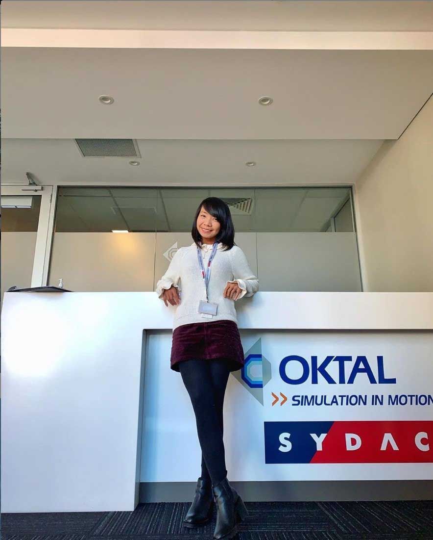 A young Asian woman standing in front of her office 