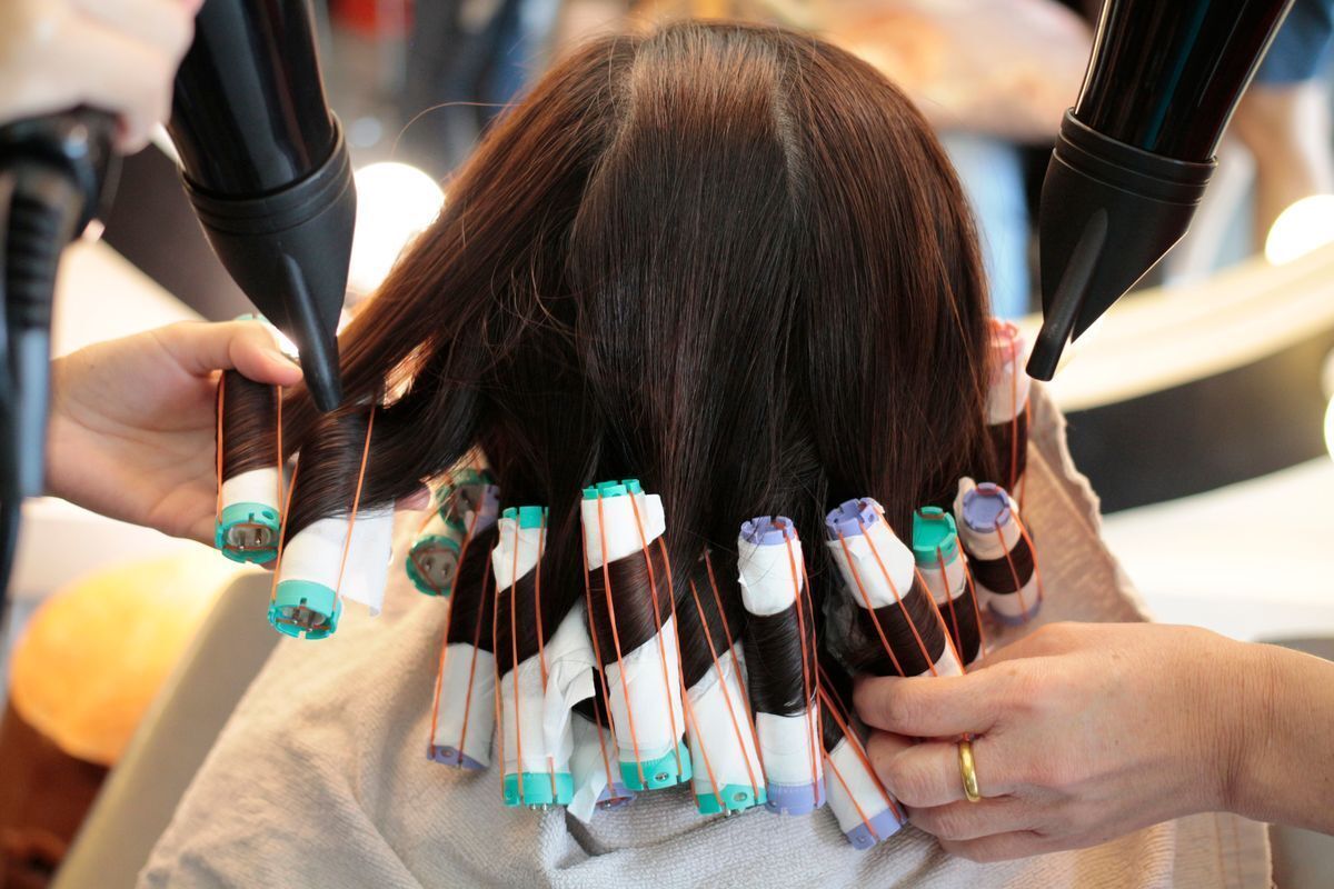 Woman getting her hair permed at the salon.