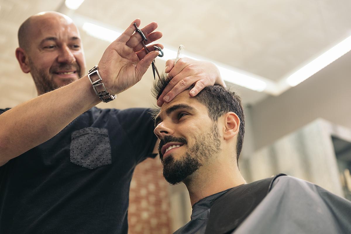 A barber gives a client an updated take on the spiky hair trend