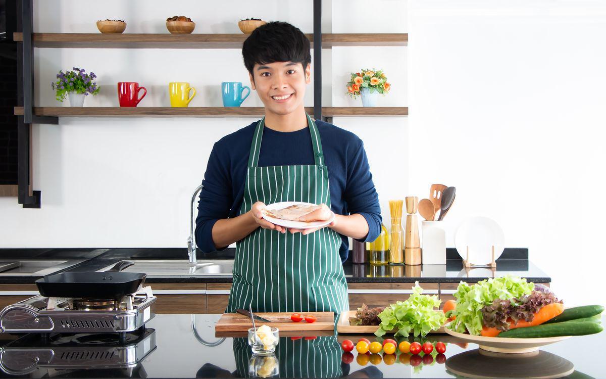 Asian man cooking white meat