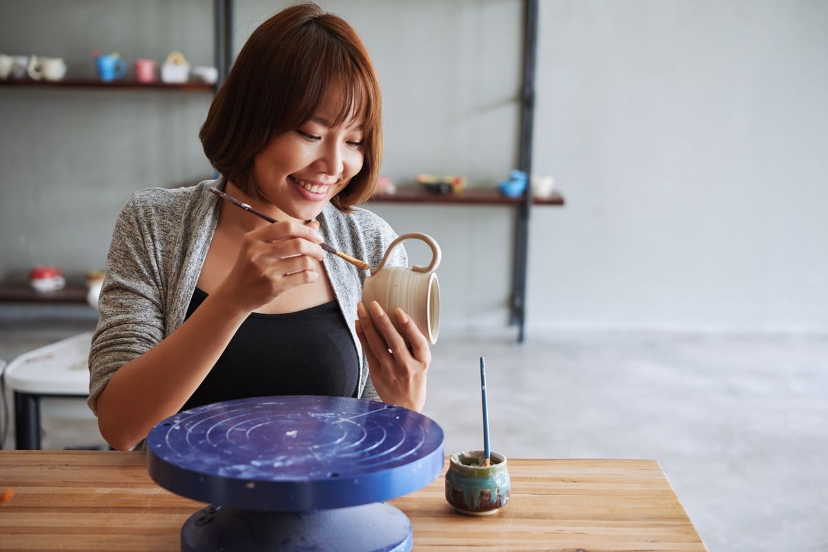 Asian woman with short hair doing pottery