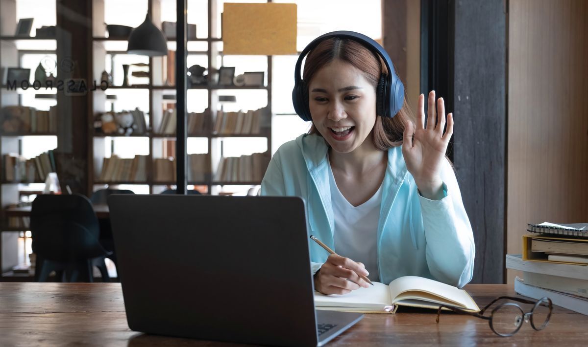 Asian woman saying hello during a virtual meeting