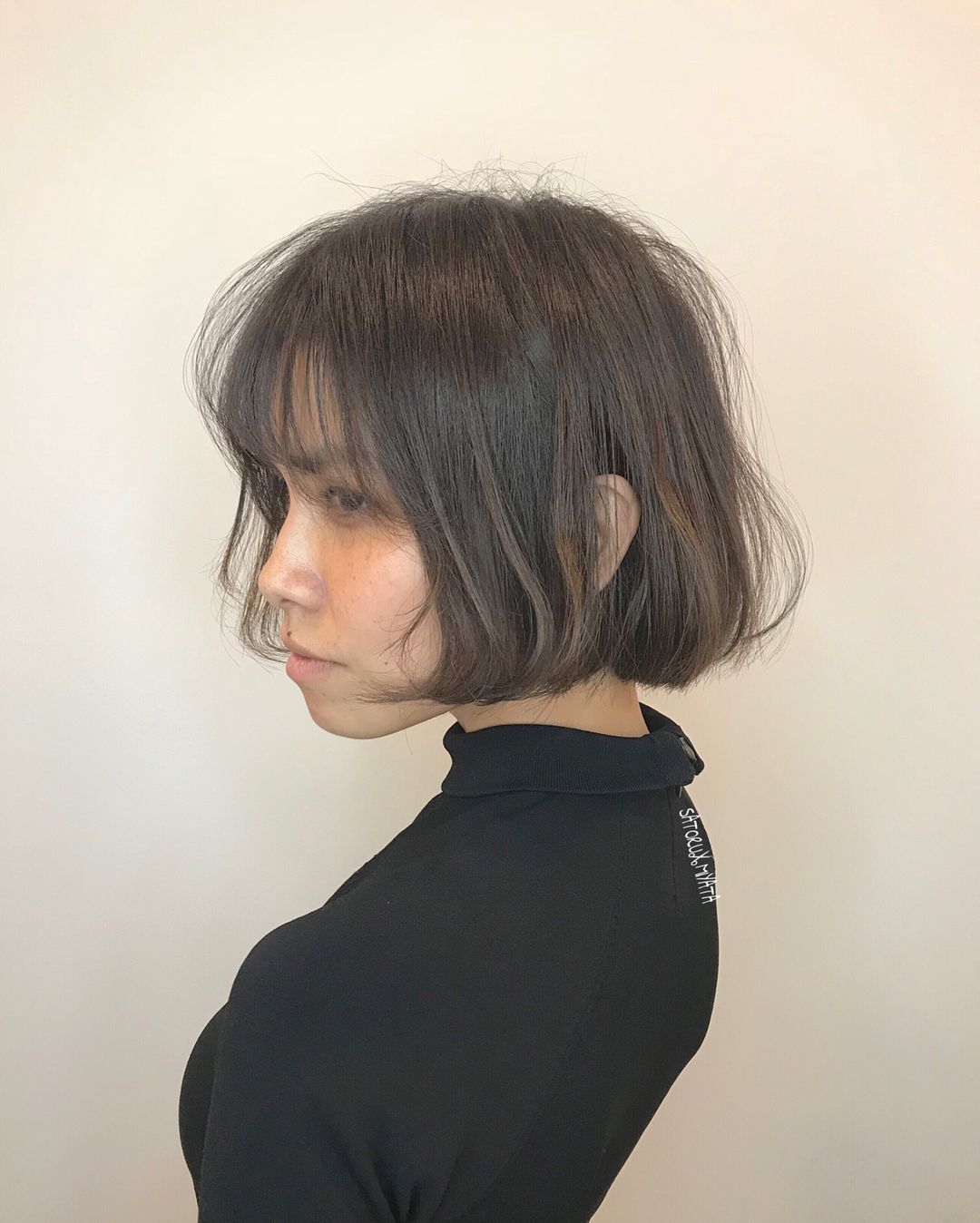 Woman with brown French bob and fringe.