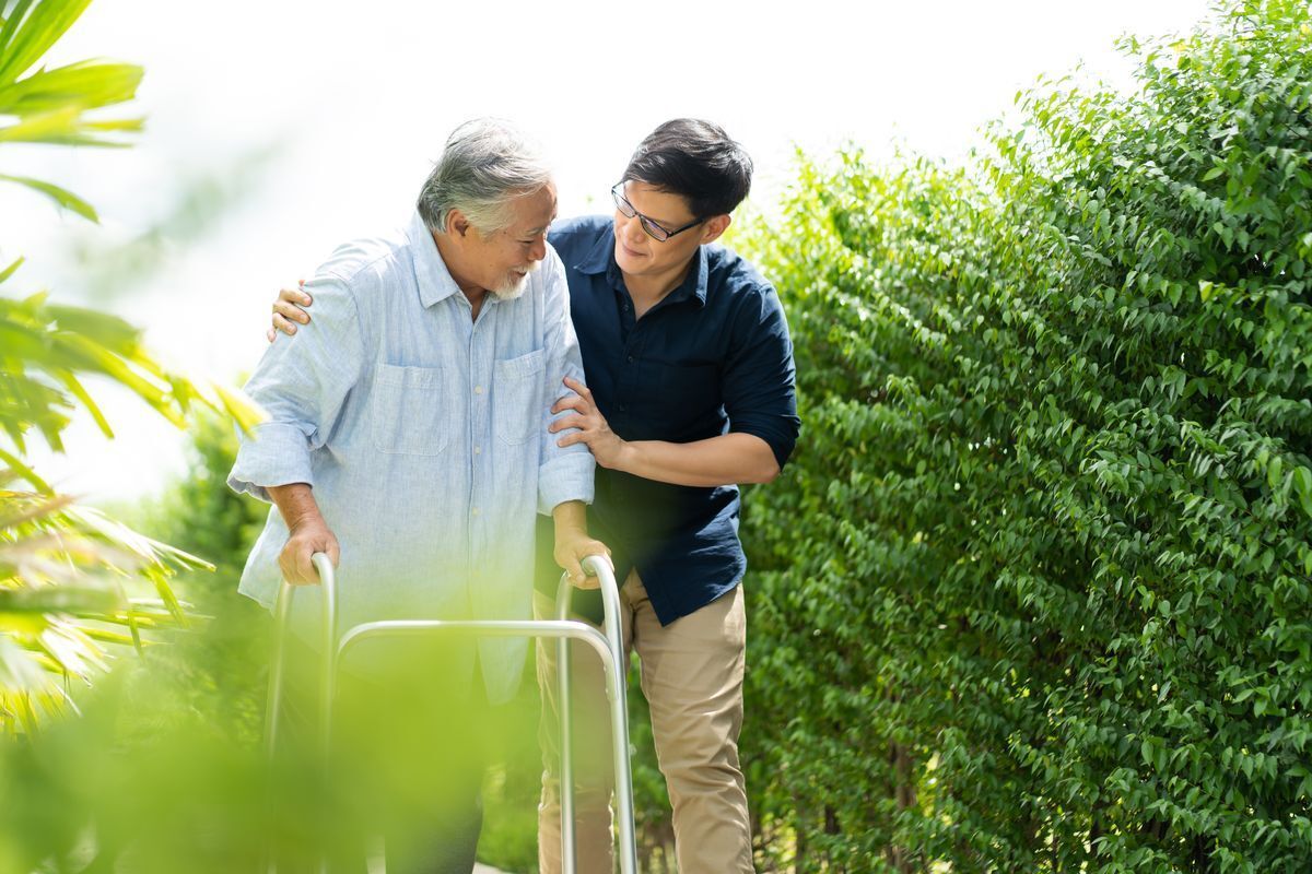 Asian man helping elderly