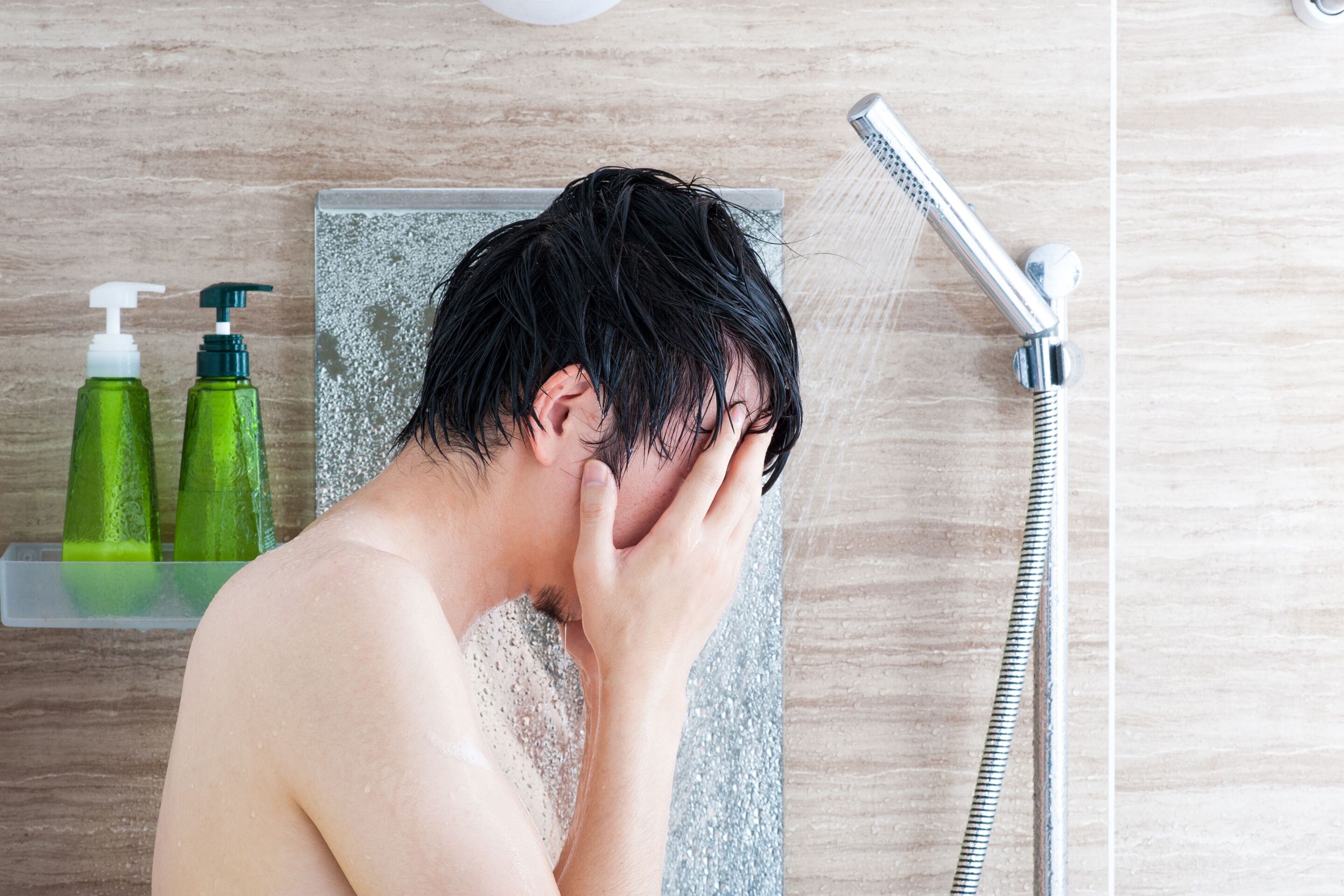 An Asian man taking a shower