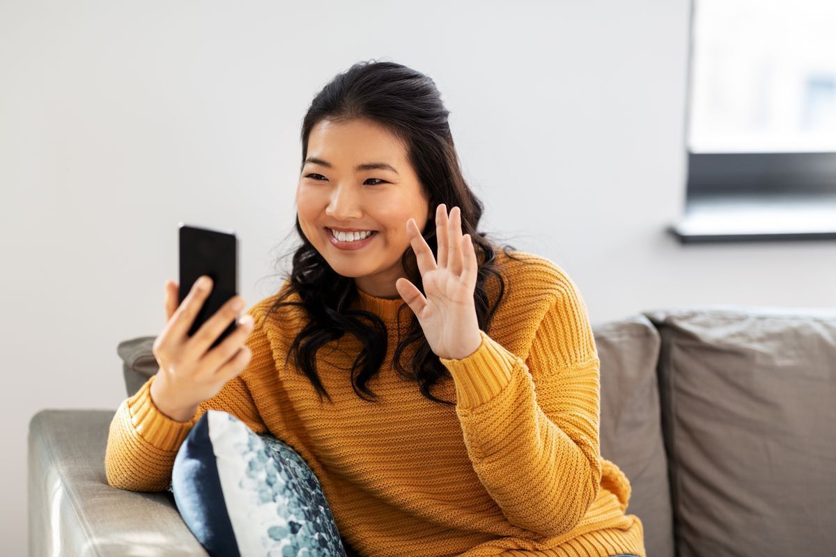 Asian woman in yellow sweating during video chat