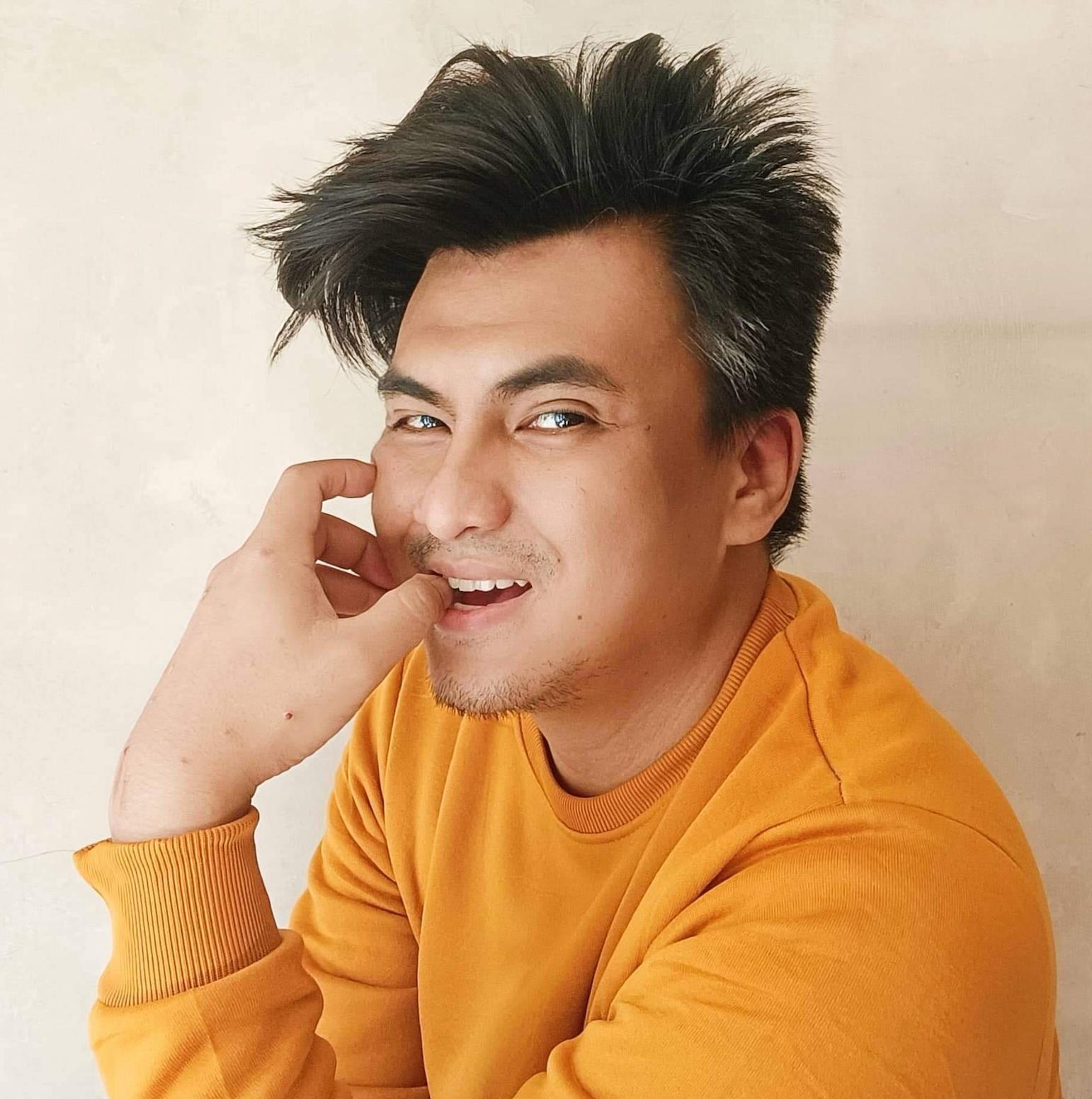 Asian man in mustard yellow sweater