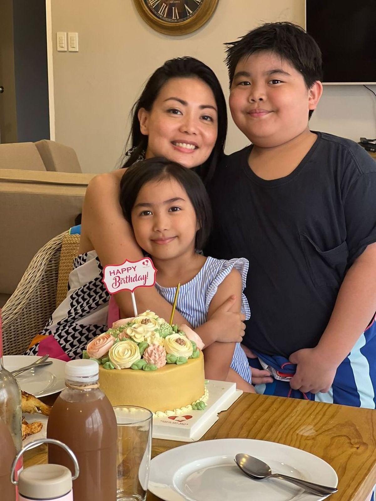 Asian mom with two kids with cake 
