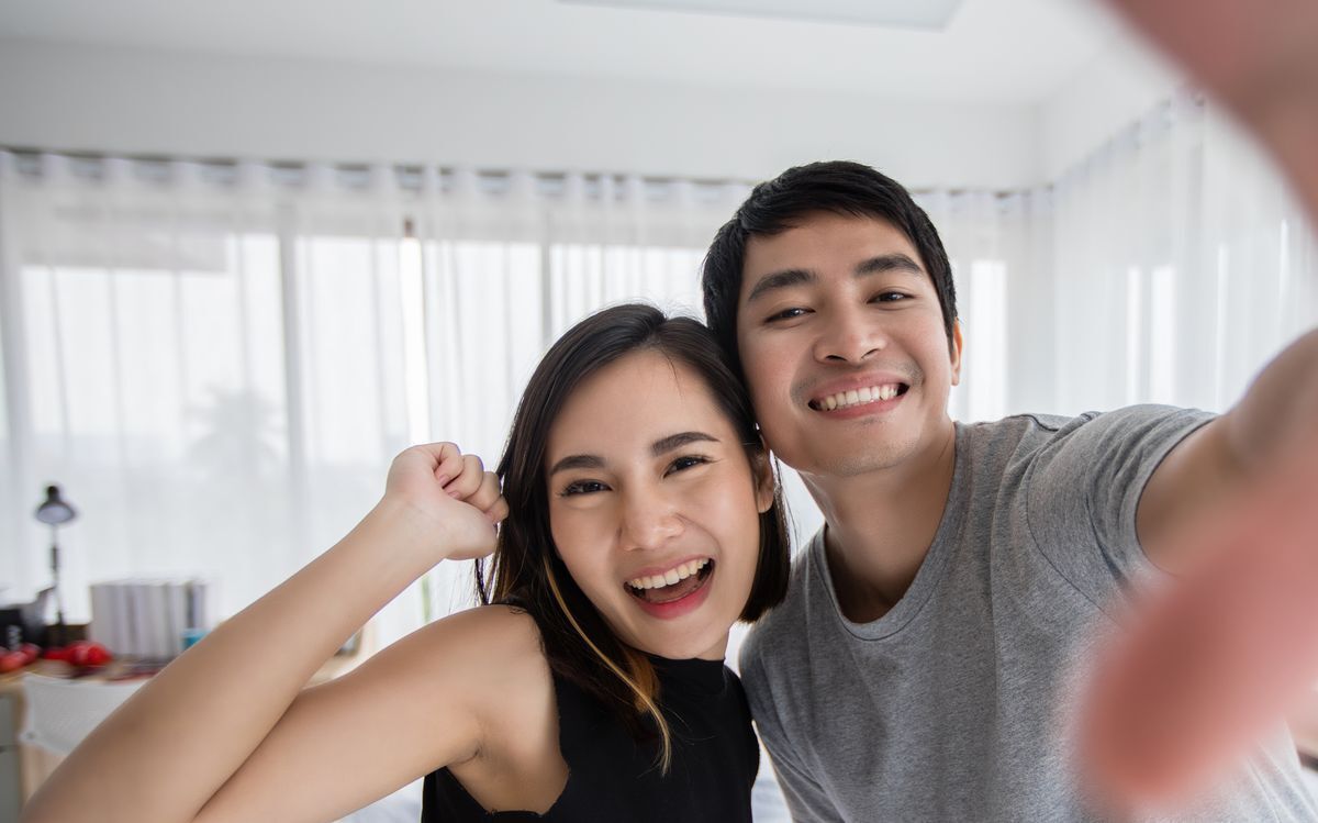 Asian couple taking a selfie at home