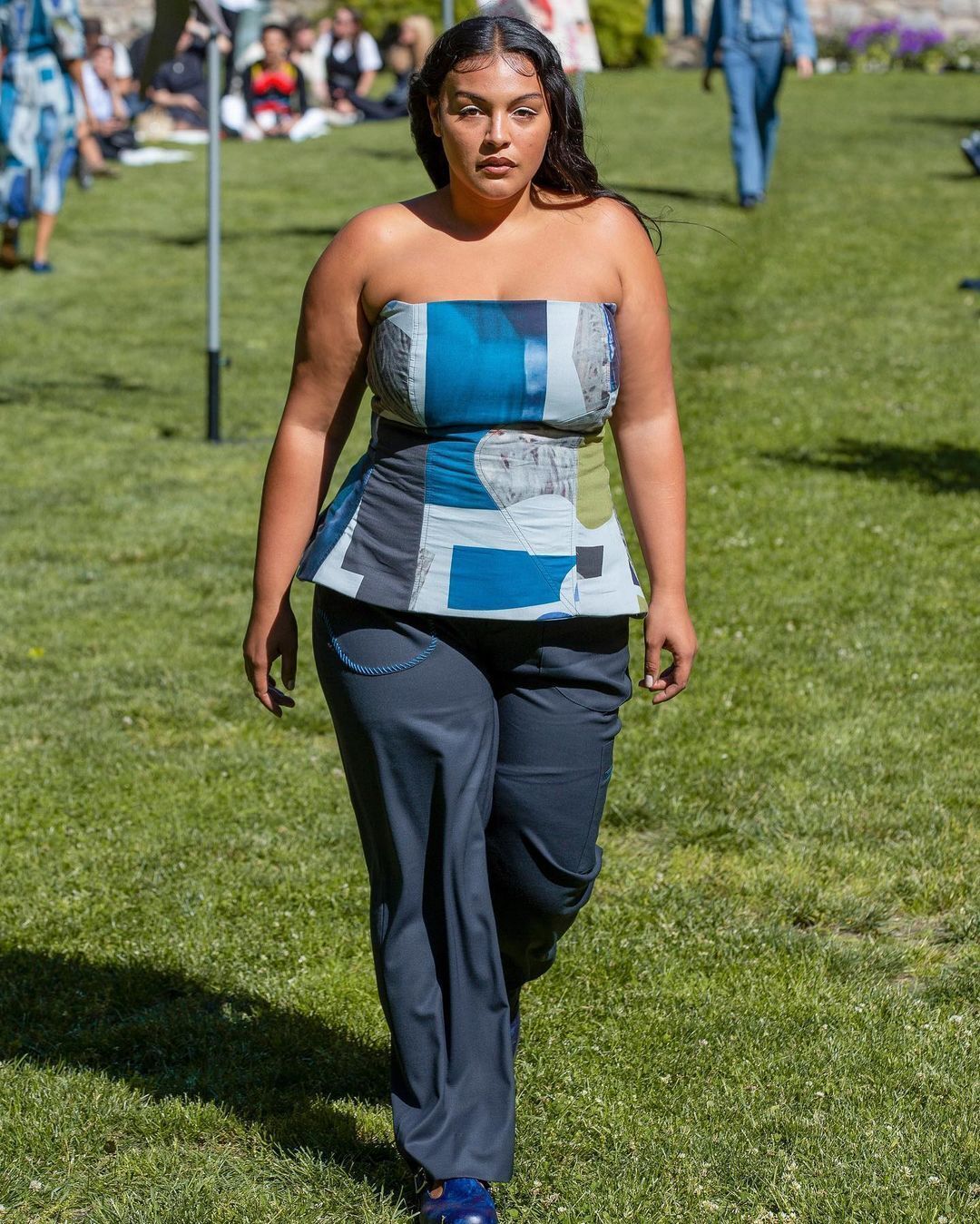 A portrait of woman wearing a tube top and loose pants.