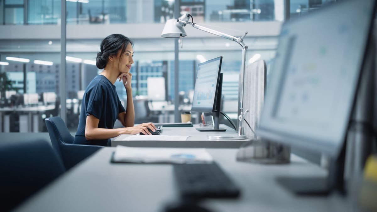 Woman working in front of a computer at an office. 