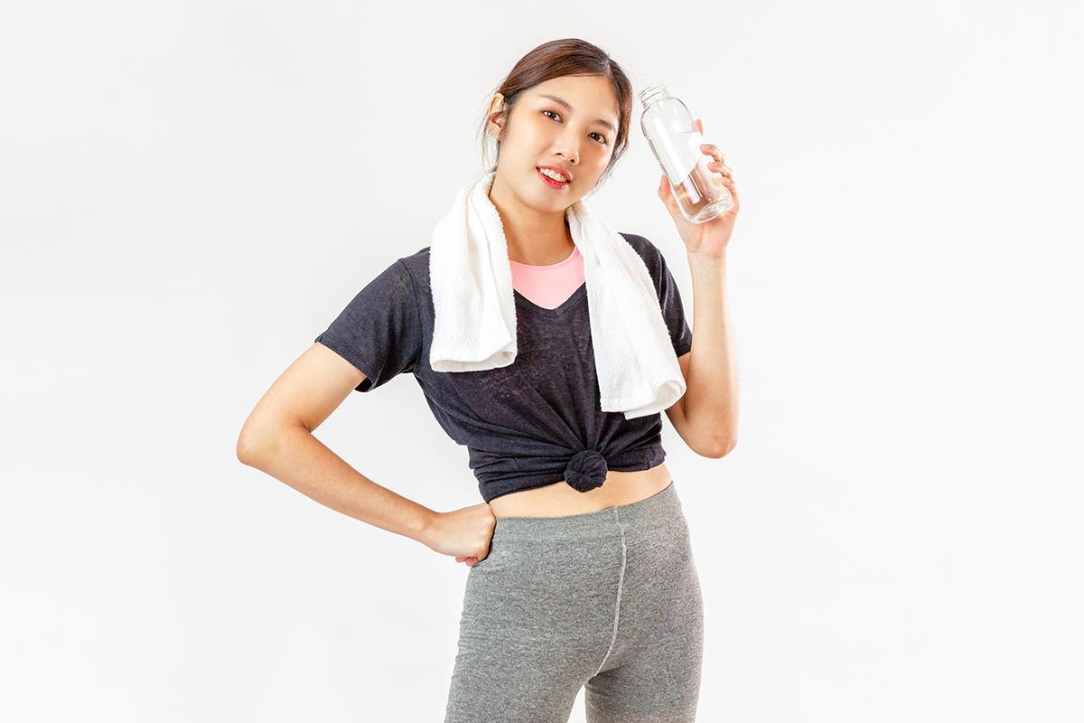 Asian woman in tie front shirt holding water