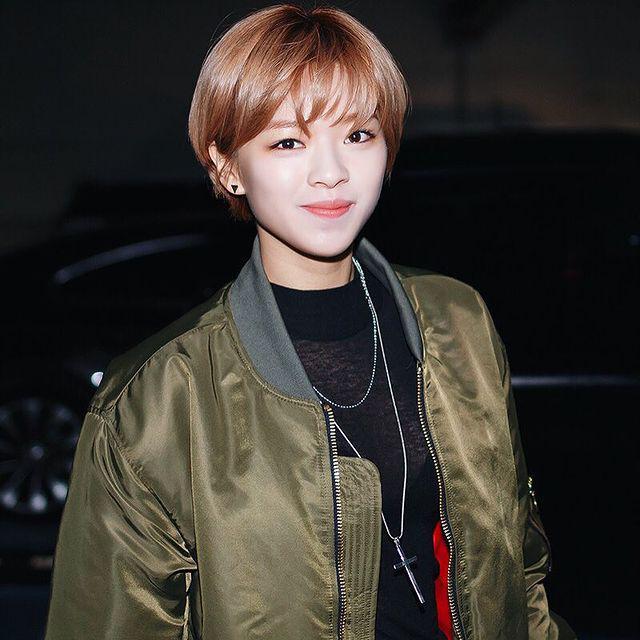 Asian woman with short brown hair smiling at the camera.