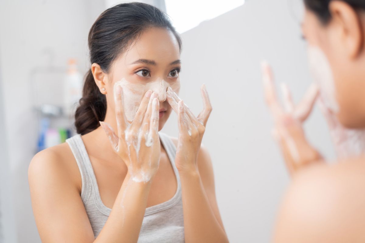 Asian woman washing her face in the bathroom