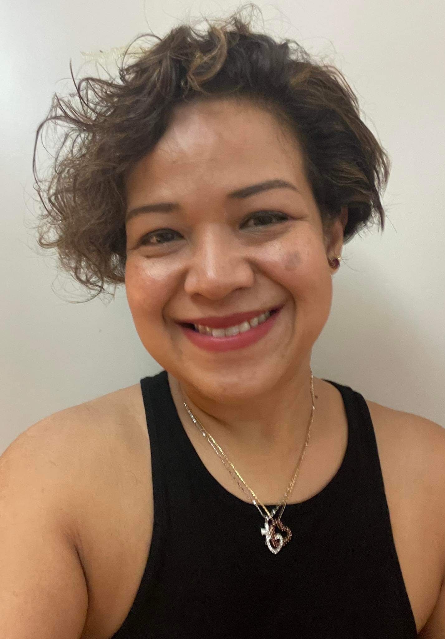 Asian woman with super short curly hair.