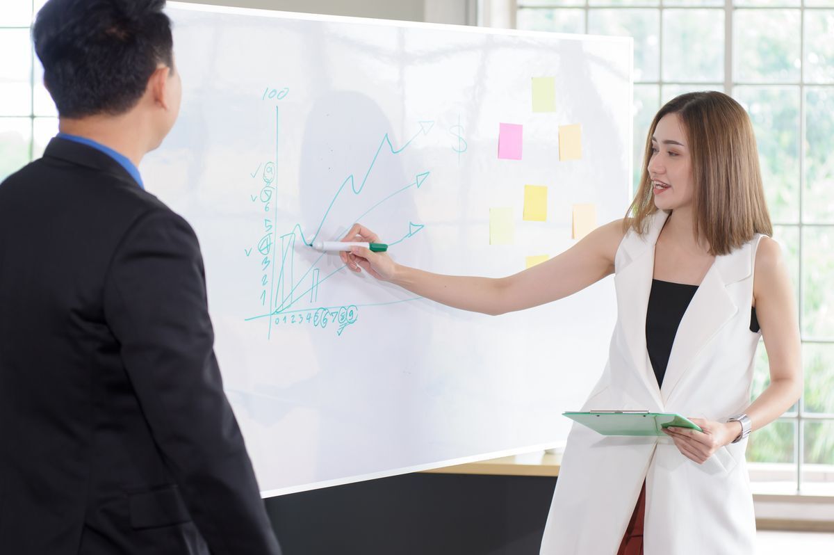 Asian woman presenting to a male colleague 