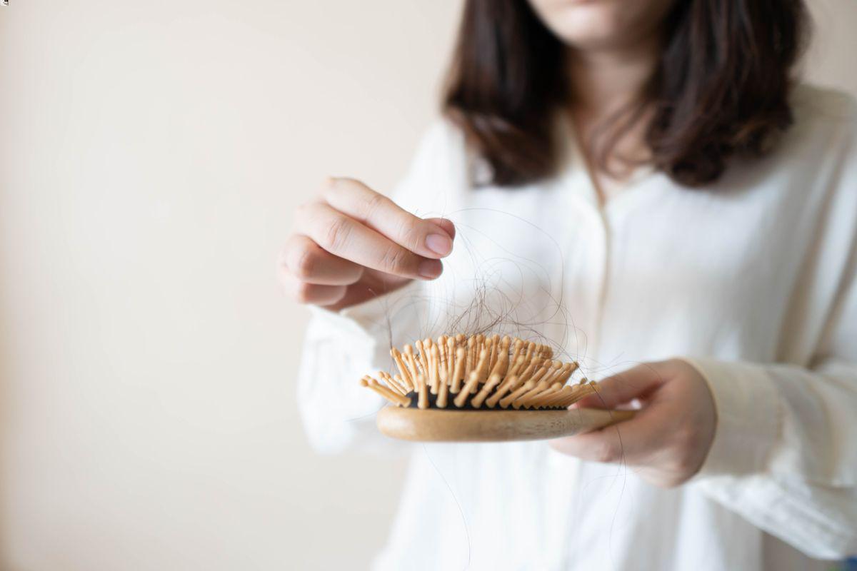 Woman holding brush with hair 