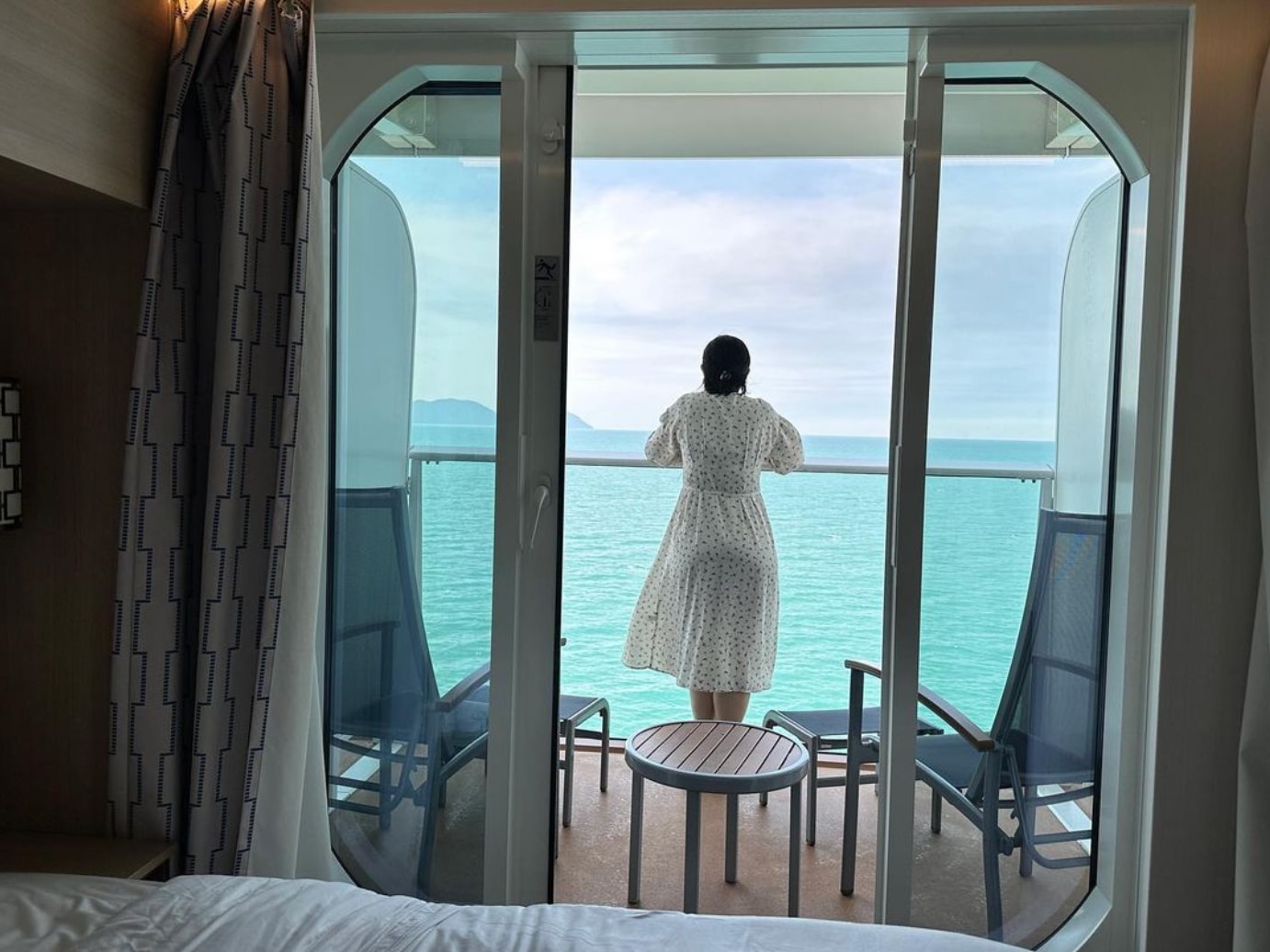 Woman on a cruise ship looking out at the ocean.