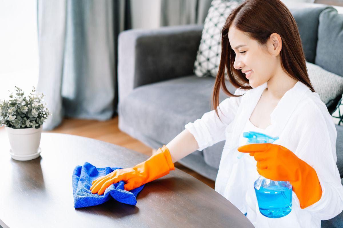 Asian woman cleaning at home wearing rubber gloves