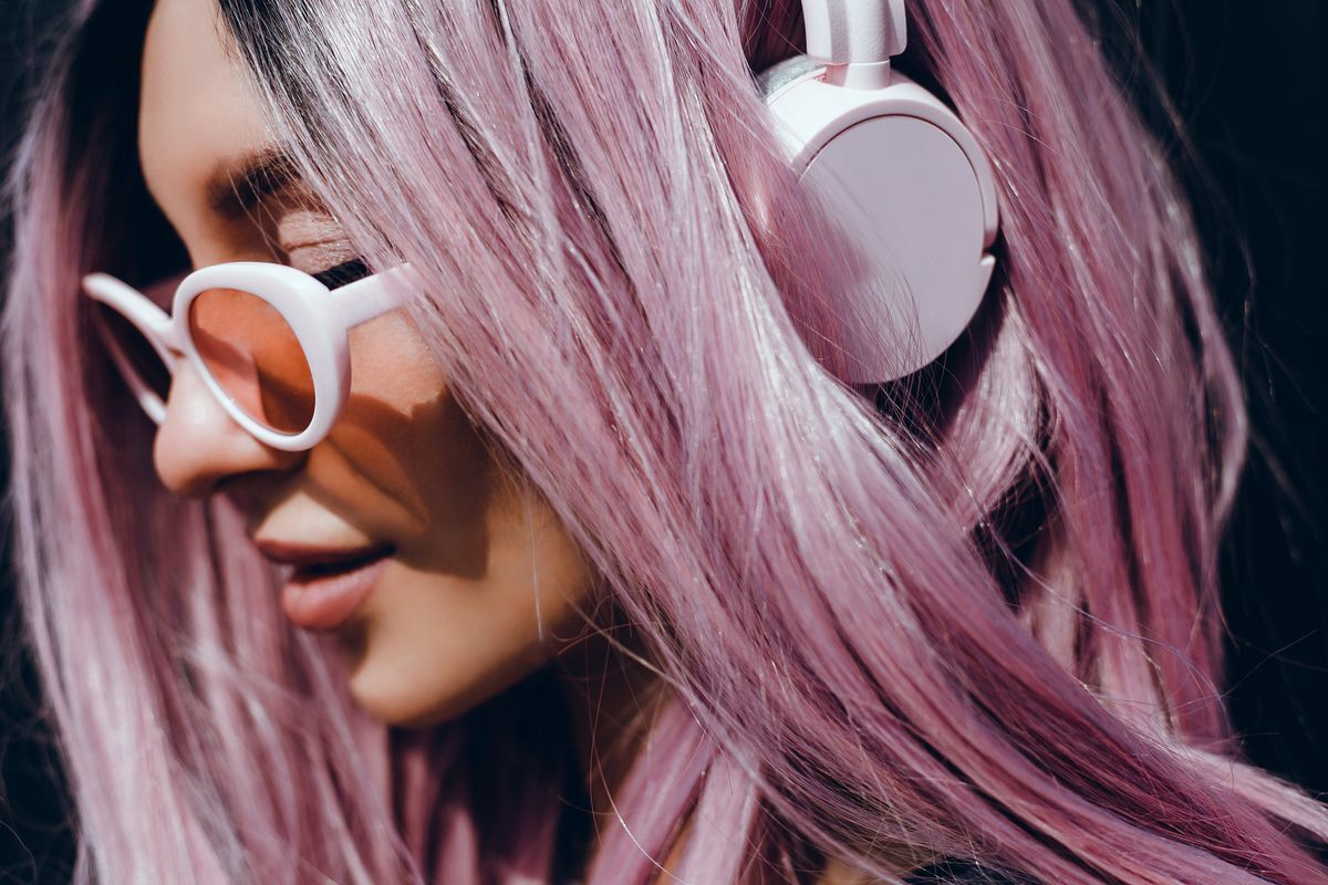 Edgy Asian woman with purple hair and metallic eyeshadow.