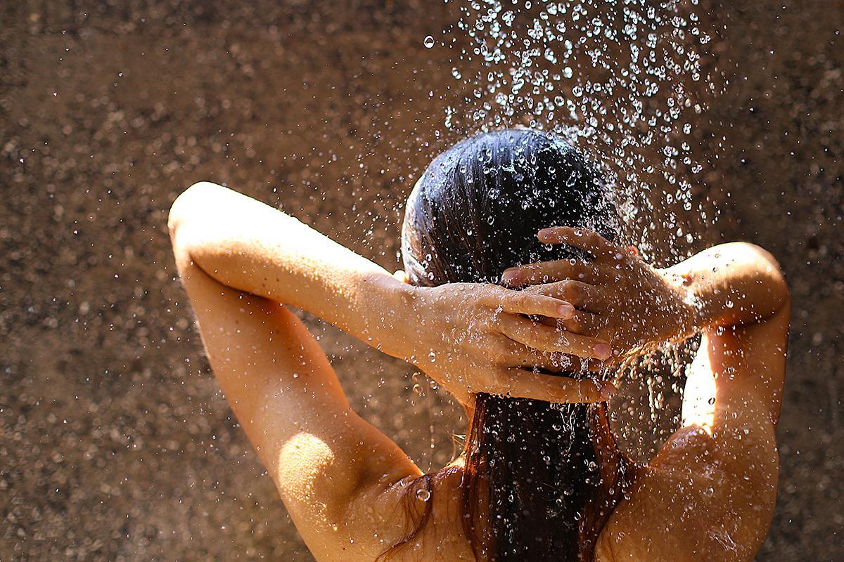 Woman rinsing hair with water